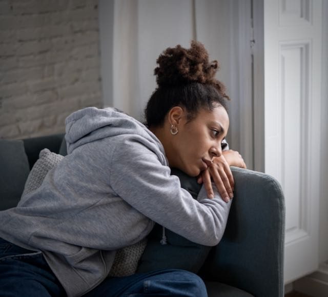 Depressed black woman on sofa