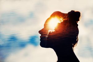Woman's silhouette in profile with double exposure of sunlit water, suggesting openness and the possibility of change after persistent depression.