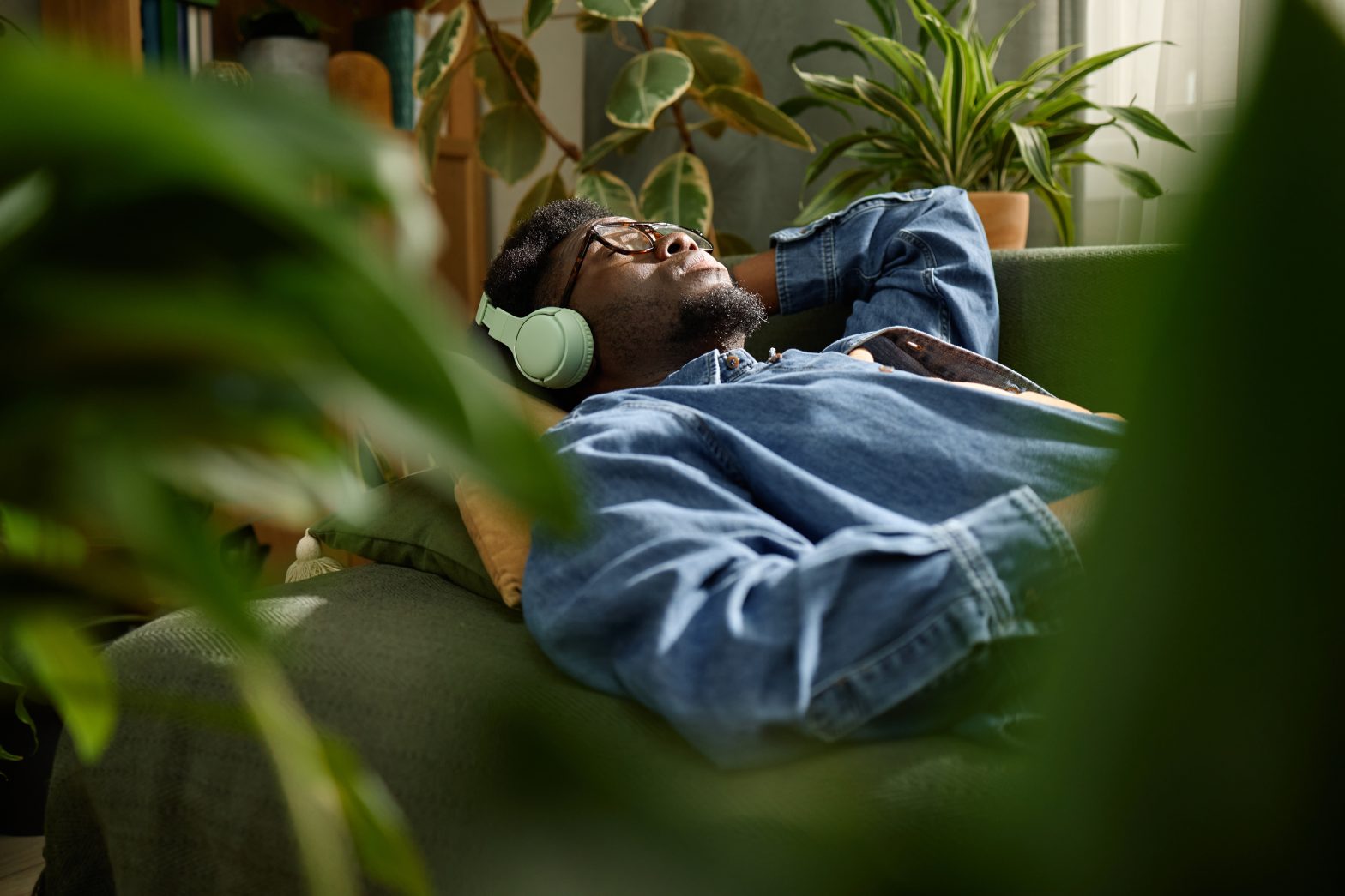 Man resting quietly at home with headphones on, eyes closed — a typical setting for an at-home ketamine therapy session