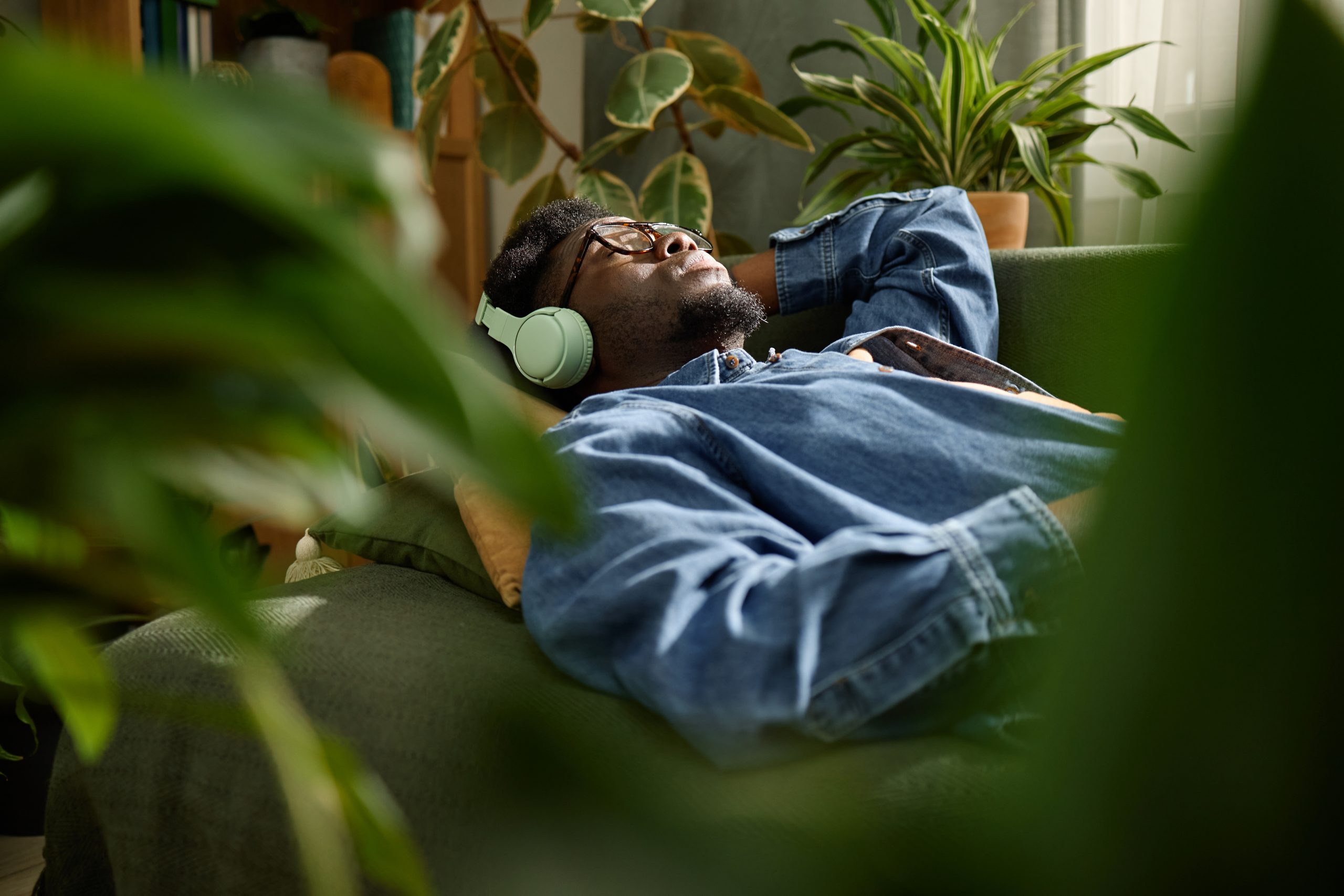 Man resting quietly at home with headphones on, eyes closed — a typical setting for an at-home ketamine therapy session