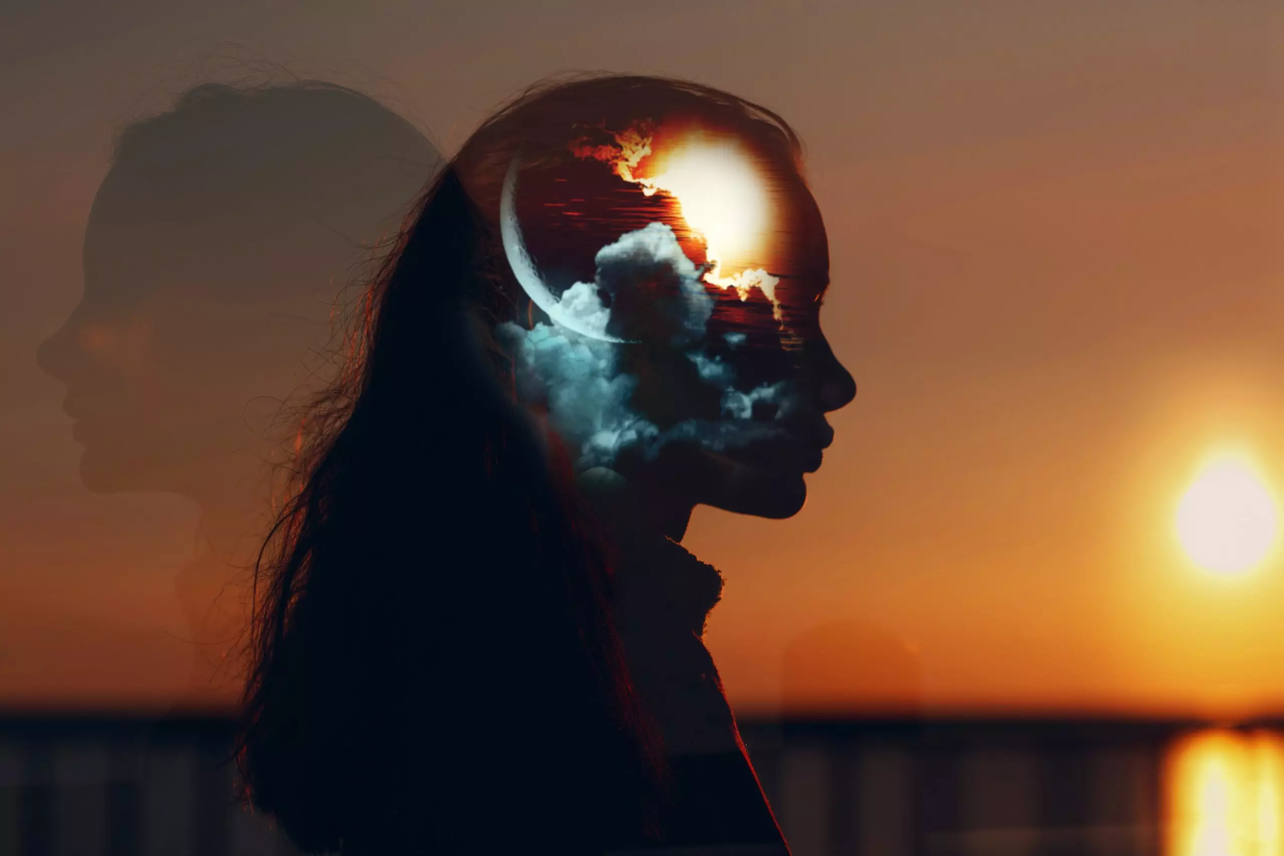 Double-exposure portrait of a woman at sunset with clouds, moon, and light layered inside her silhouette, symbolizing how to regulate your nervous system and recover from chronic stress.