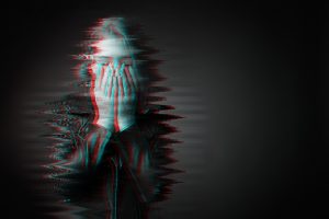 Stylized portrait of woman with hands over her face on black background representing the challenges of trauma healing with talk therapy alone.