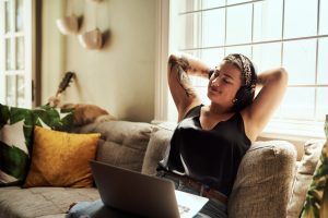 How long does ketamine therapy take to work? A woman relaxing on the sofa at home, feeling early benefits from Mindscape's daily, low-dose ketamine therapy approach.