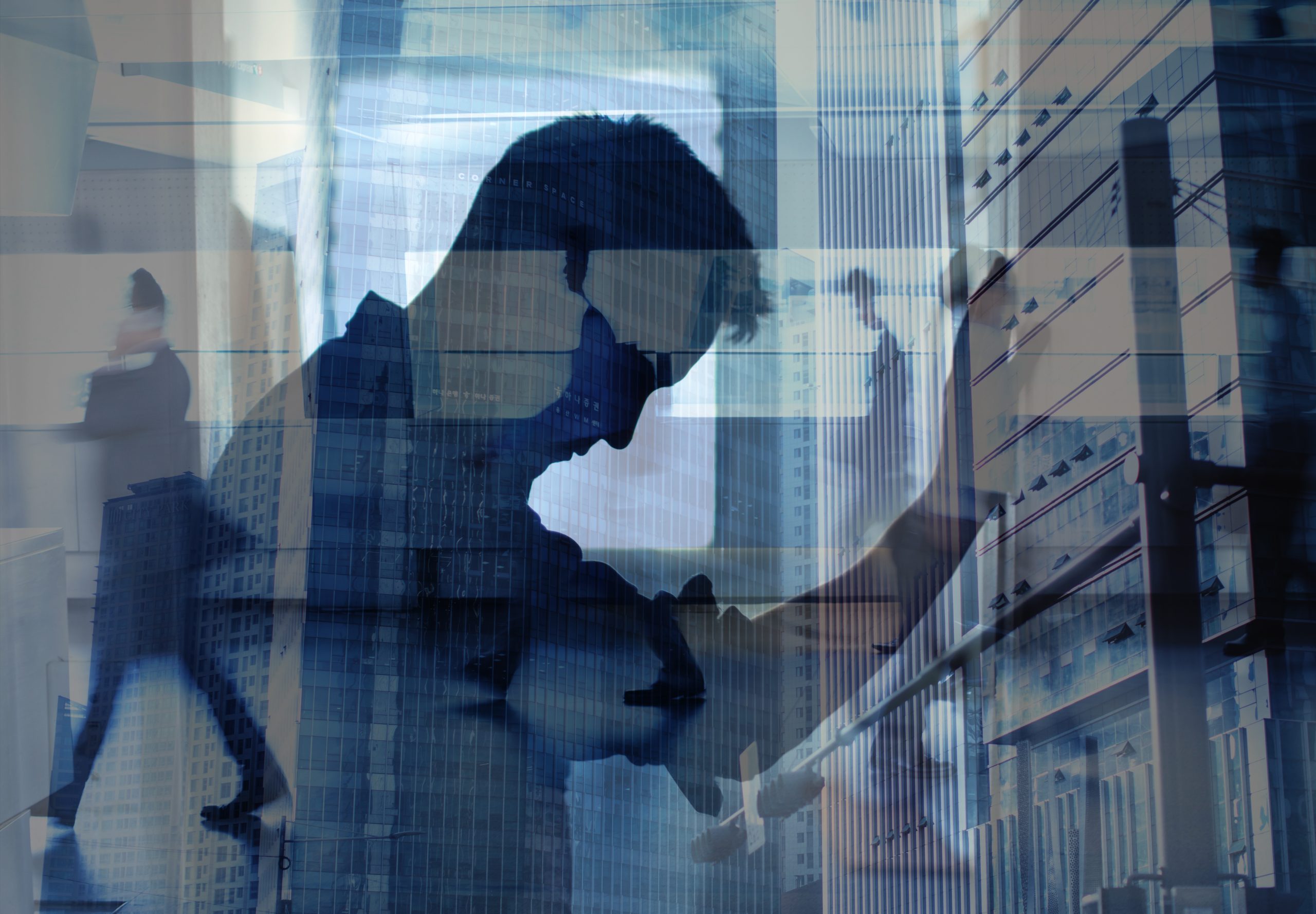 Silhouette of a man with his head bowed, layered over city office buildings and passing commuters, illustrating burnout vs depression and anxiety.